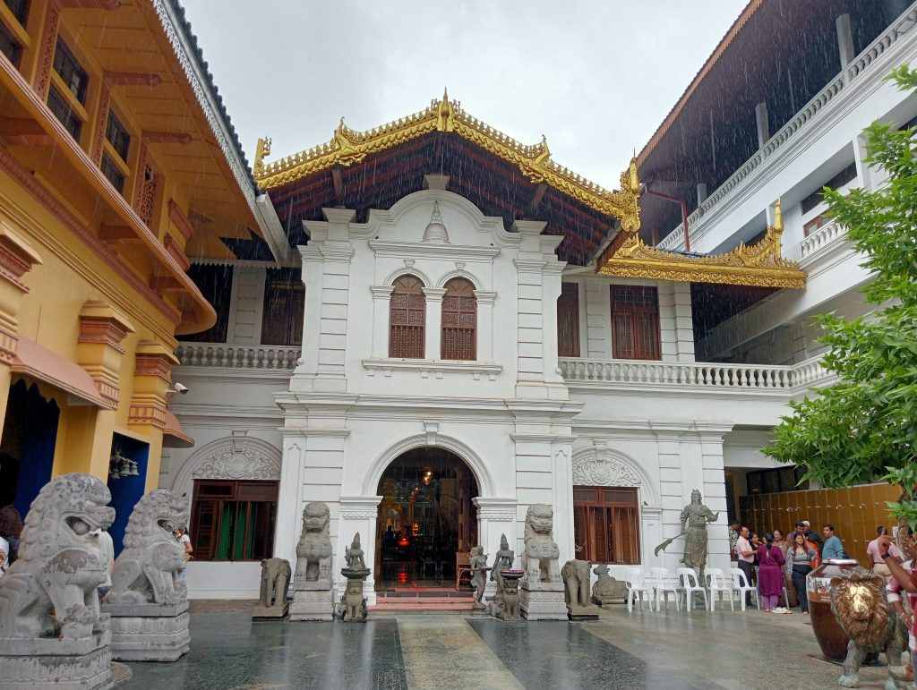 The exterior is a mix of wood, stone, concrete mixed with Chinese style roofing detail and a plethora of different statues.